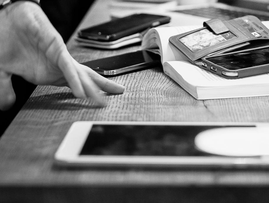Mobile phones on a table together with a hand. Foto: Thomas Ekström/Sikresiden